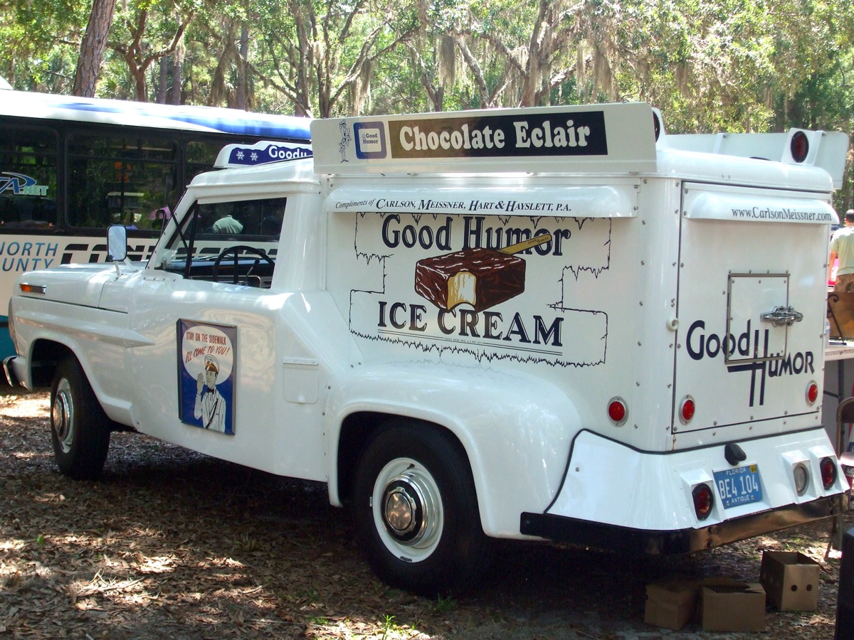 a white car with a covered large back truck that has the signs 