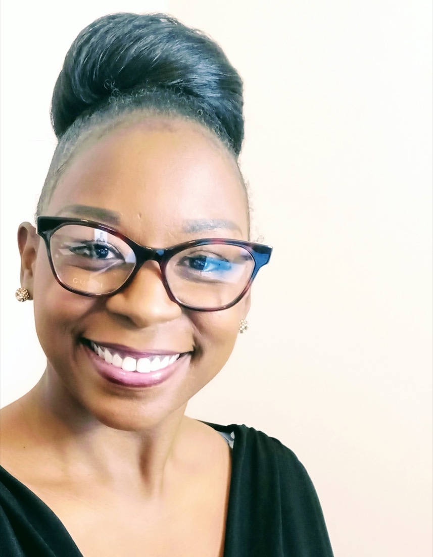 a black woman with glasses smiling