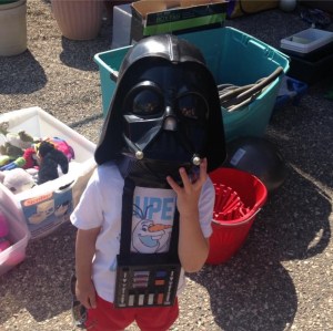 a child wearing a darth vadar mask