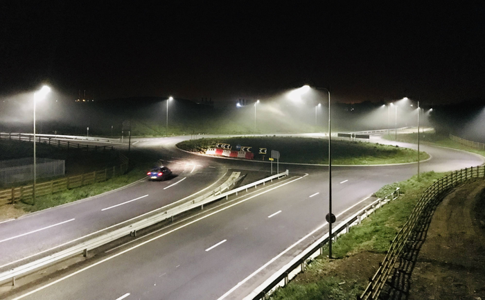 a round-about intersection that is brightly illuminated by led streetlights