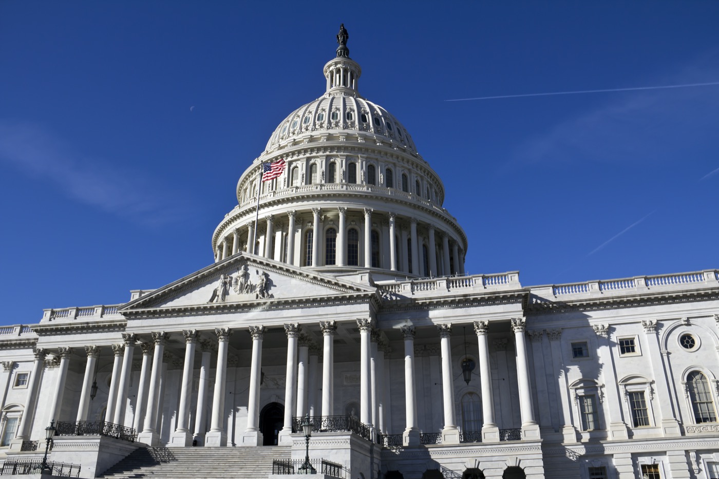 looking up at the u.s. capitol building on a cloudless day