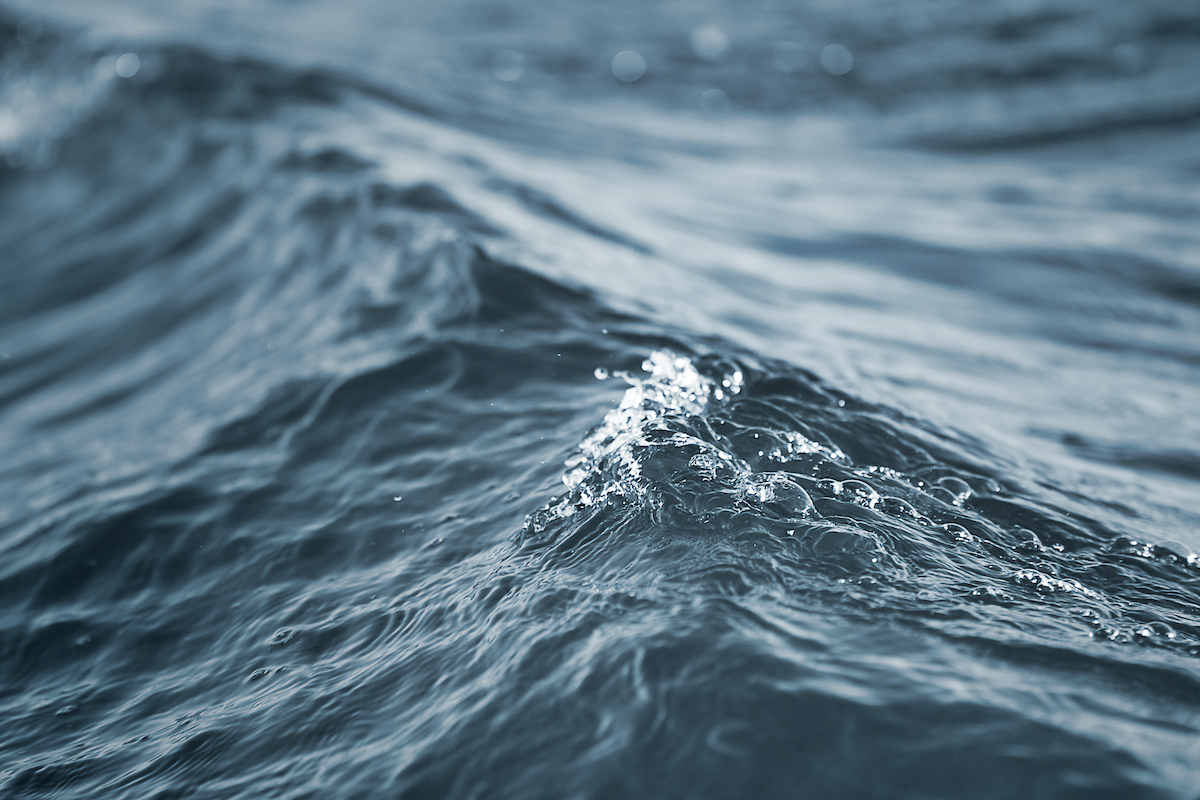 close up shot of grayish blueish water peaking as a wave