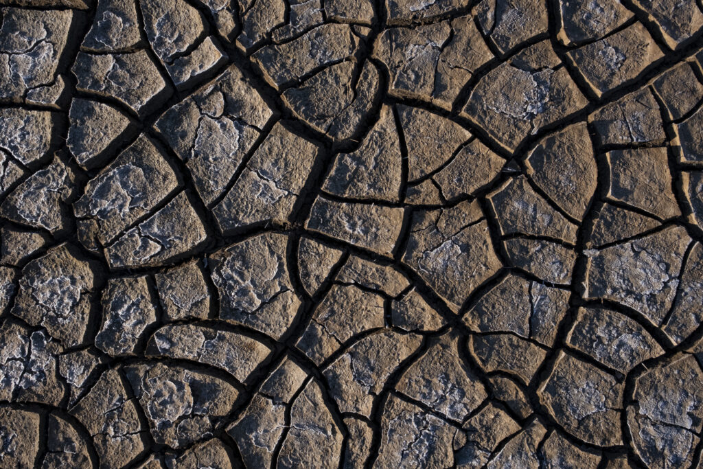 a top down shot of a severely cracked and dry riverbed