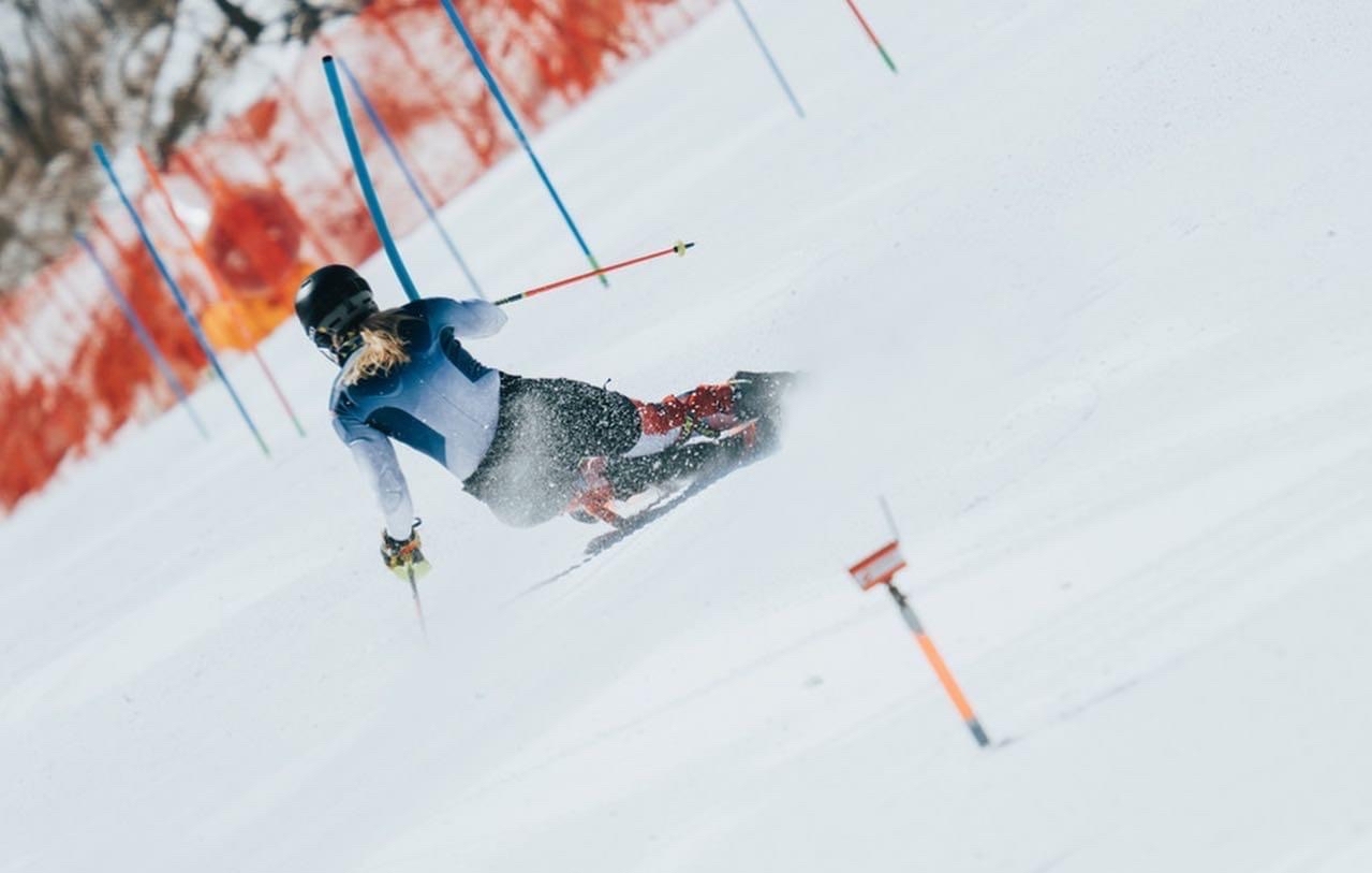 a skiier skiing downhill, photographed from the back