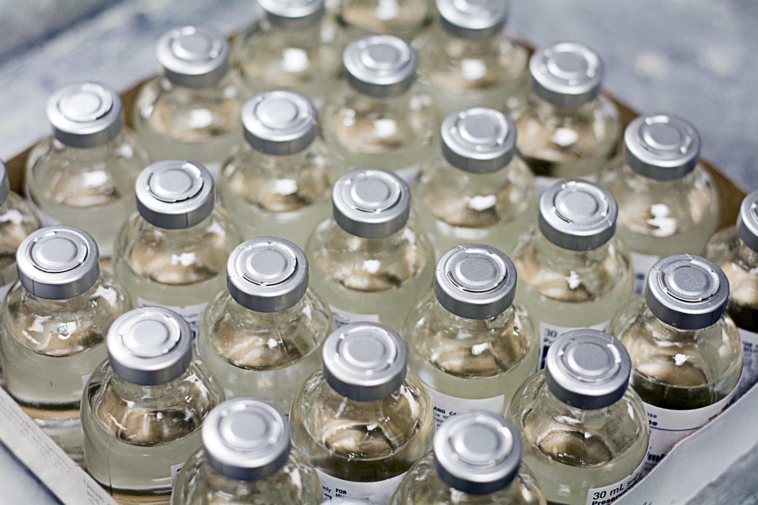 a box of over a dozen vaccine vials