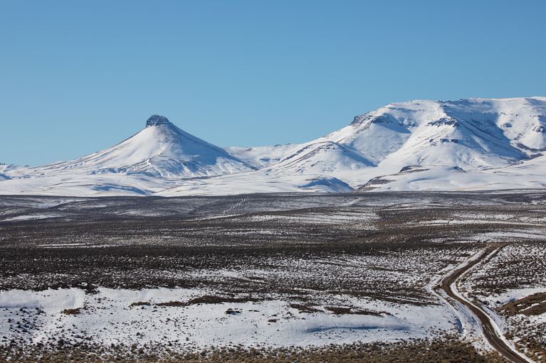 a landscape with snow-covered mountains in the background