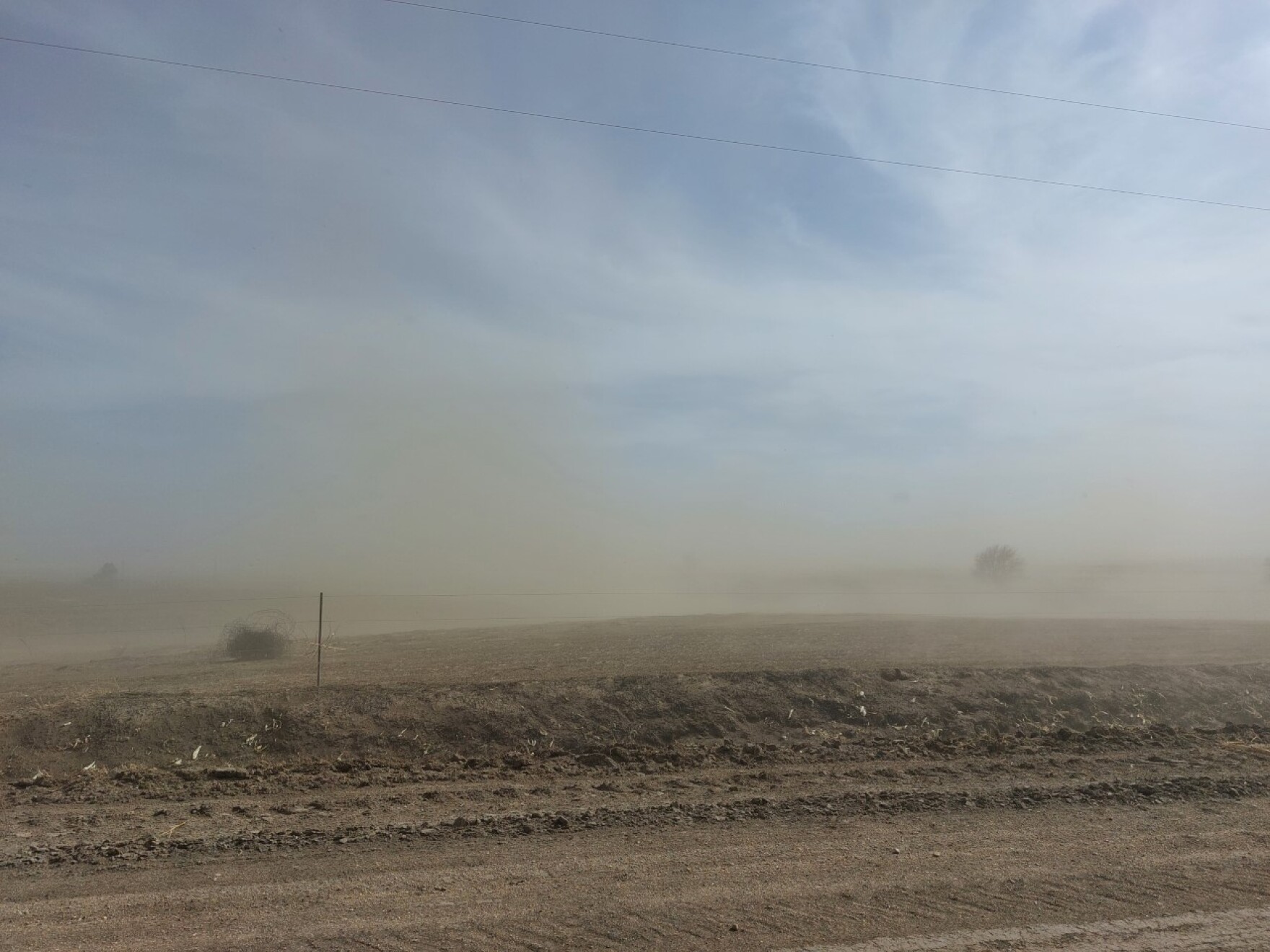 clouds of dust roll over a dry field