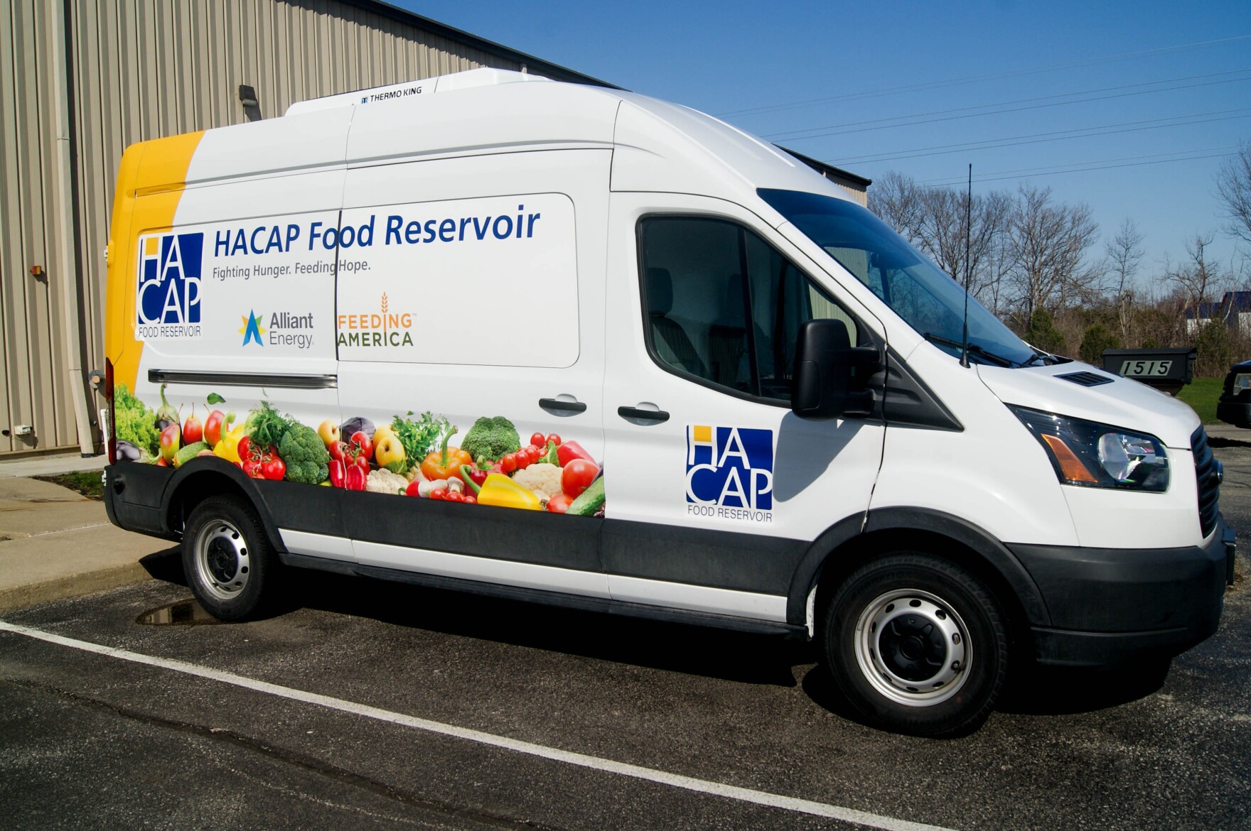 A van with pictures of food on it, labeled "HACAP Food Reservoir"