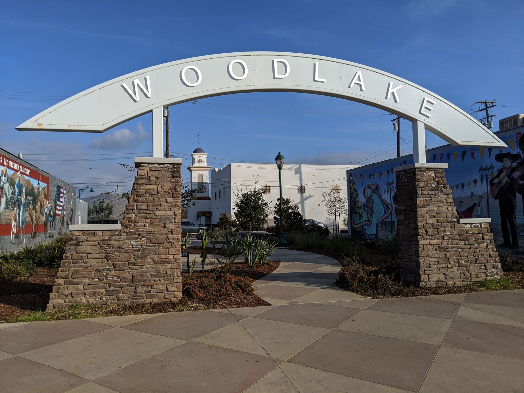 an arching town sign that says woodlake