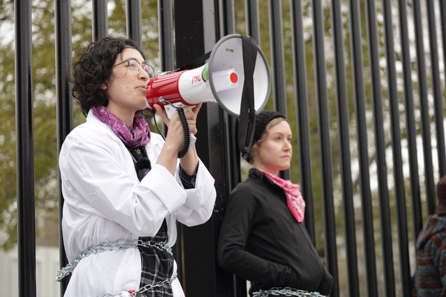 Two climate organizers, one speaking into a a megaphone