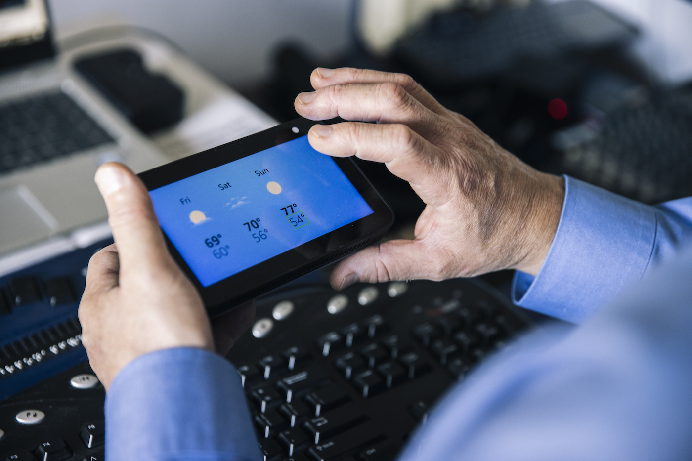 Josh Miele holds an Amazon Echo Show in his hands and uses the VoiceView screen reader to check the weather. The screen displays the weekend forecast.