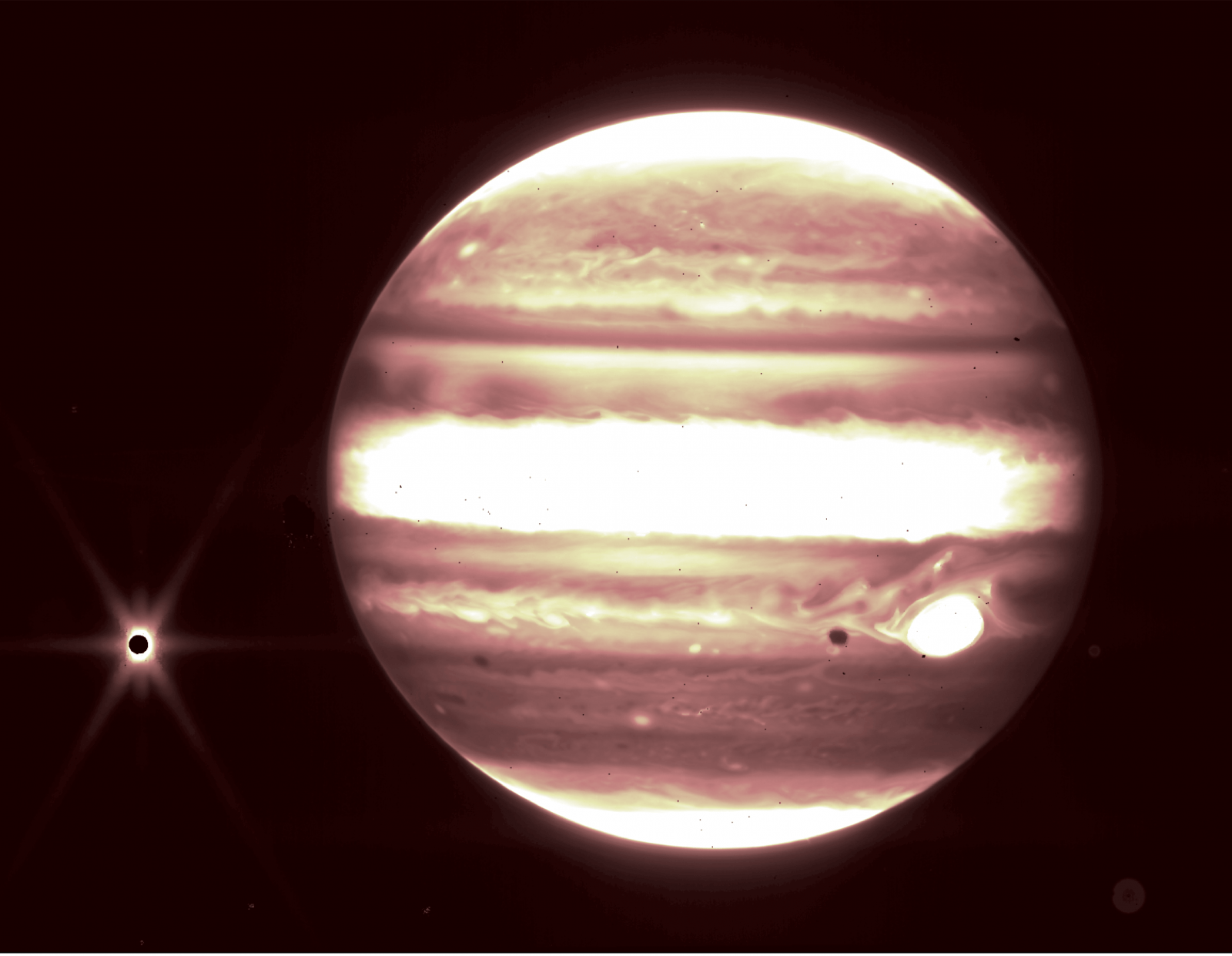 a somewhat blurry and monochromatic image of jupiter with no stars in the background, with a small white dot to its left, which is europa