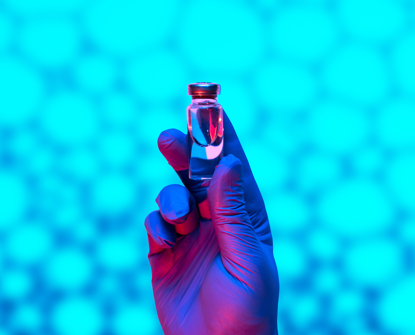 The doctor holds an ampoule with a vaccine liquid inside. Hand in medical glove, background of cancer cells.