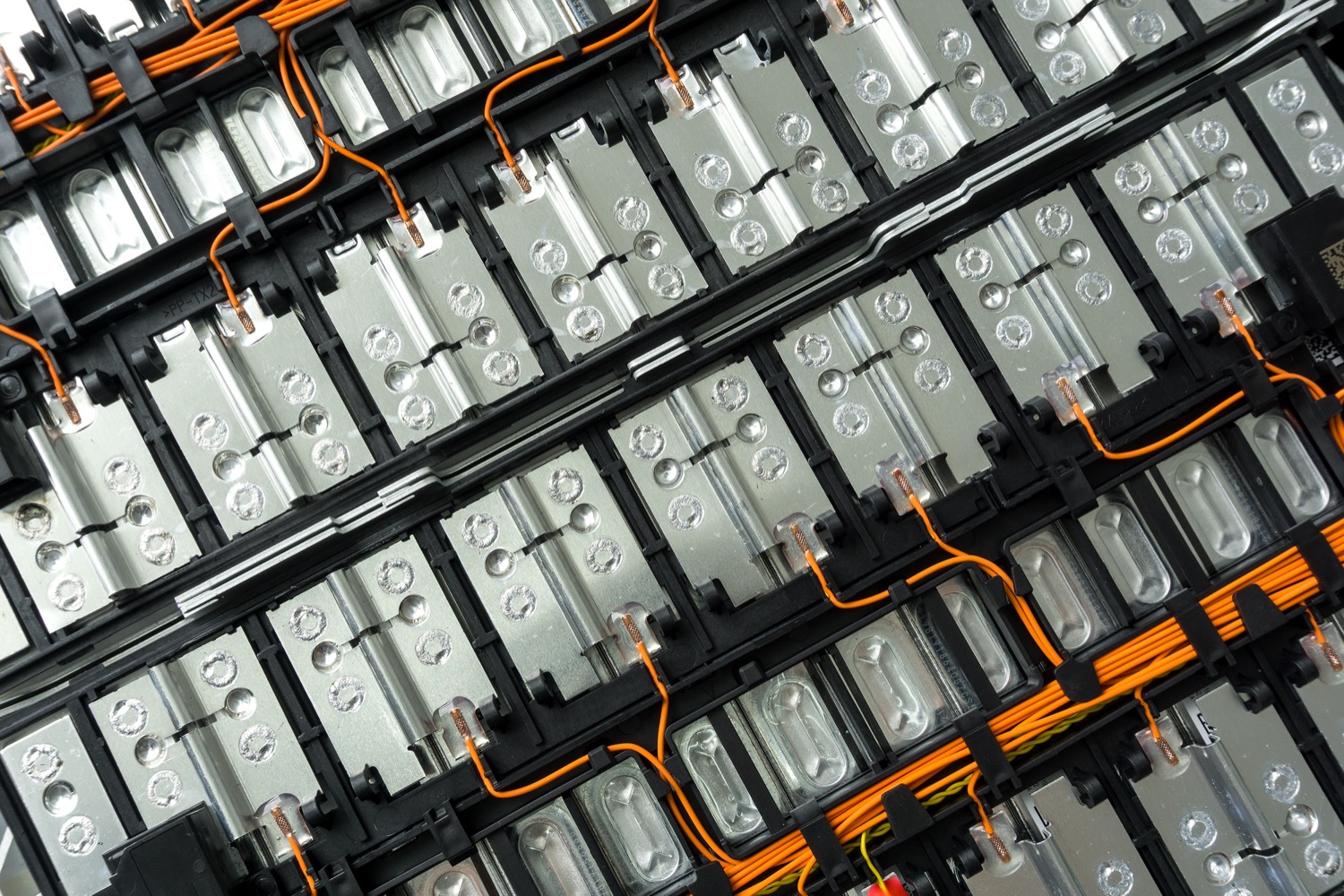 rows of silver batteries connected with orange wires