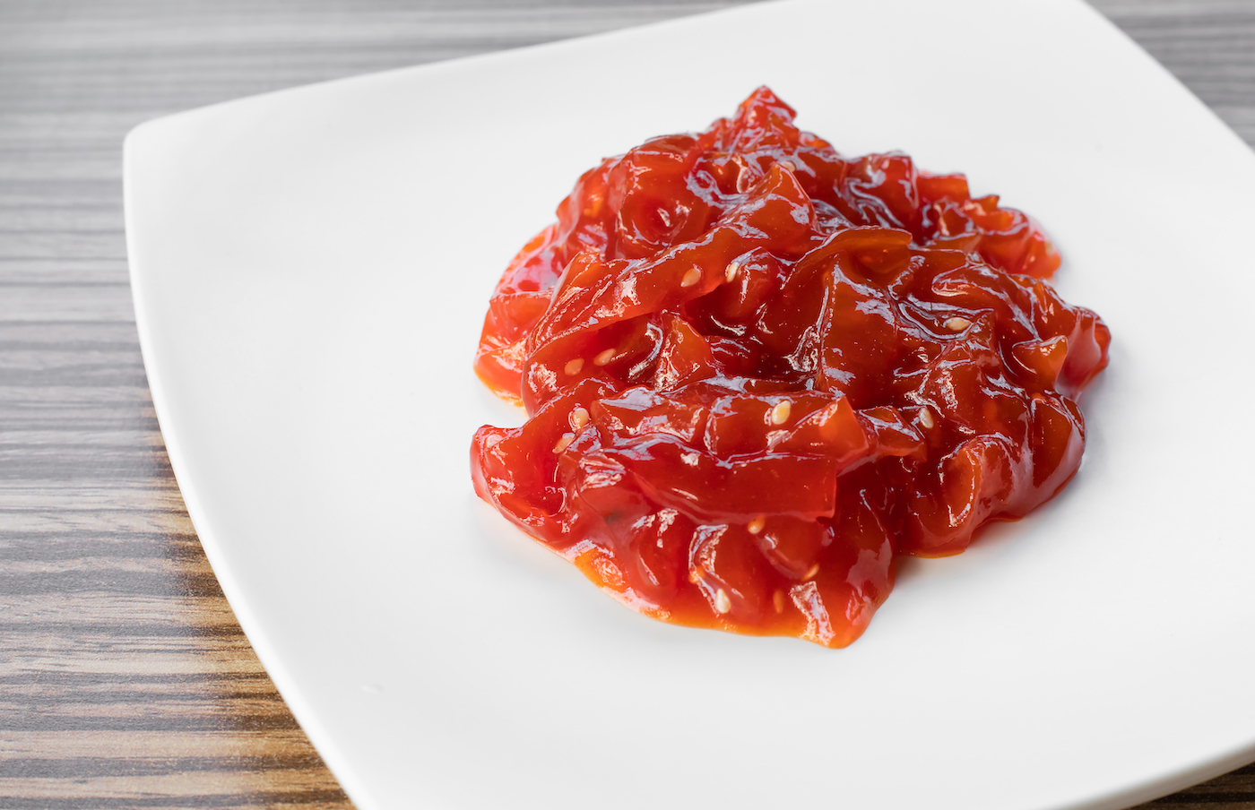 Spicy jellyfish salad with mustard garlic sauce, serving on white plate. 