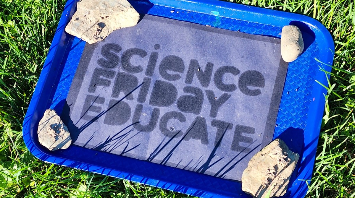 A bleached piece of black construction paper with words that read “Science Friday Educate”