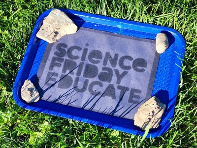 A bleached piece of black construction paper with words that read “Science Friday Educate”