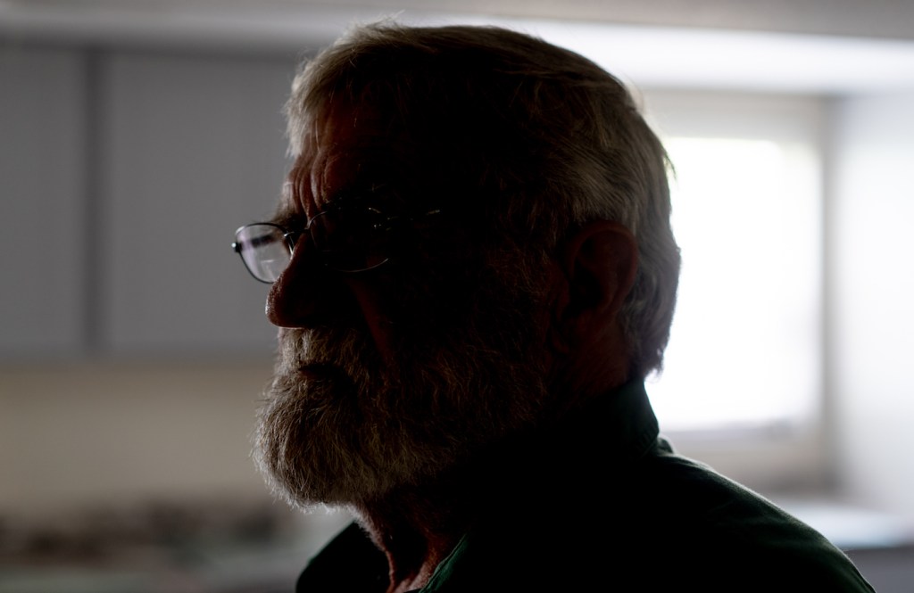 The silhouette of an older man with glasses.