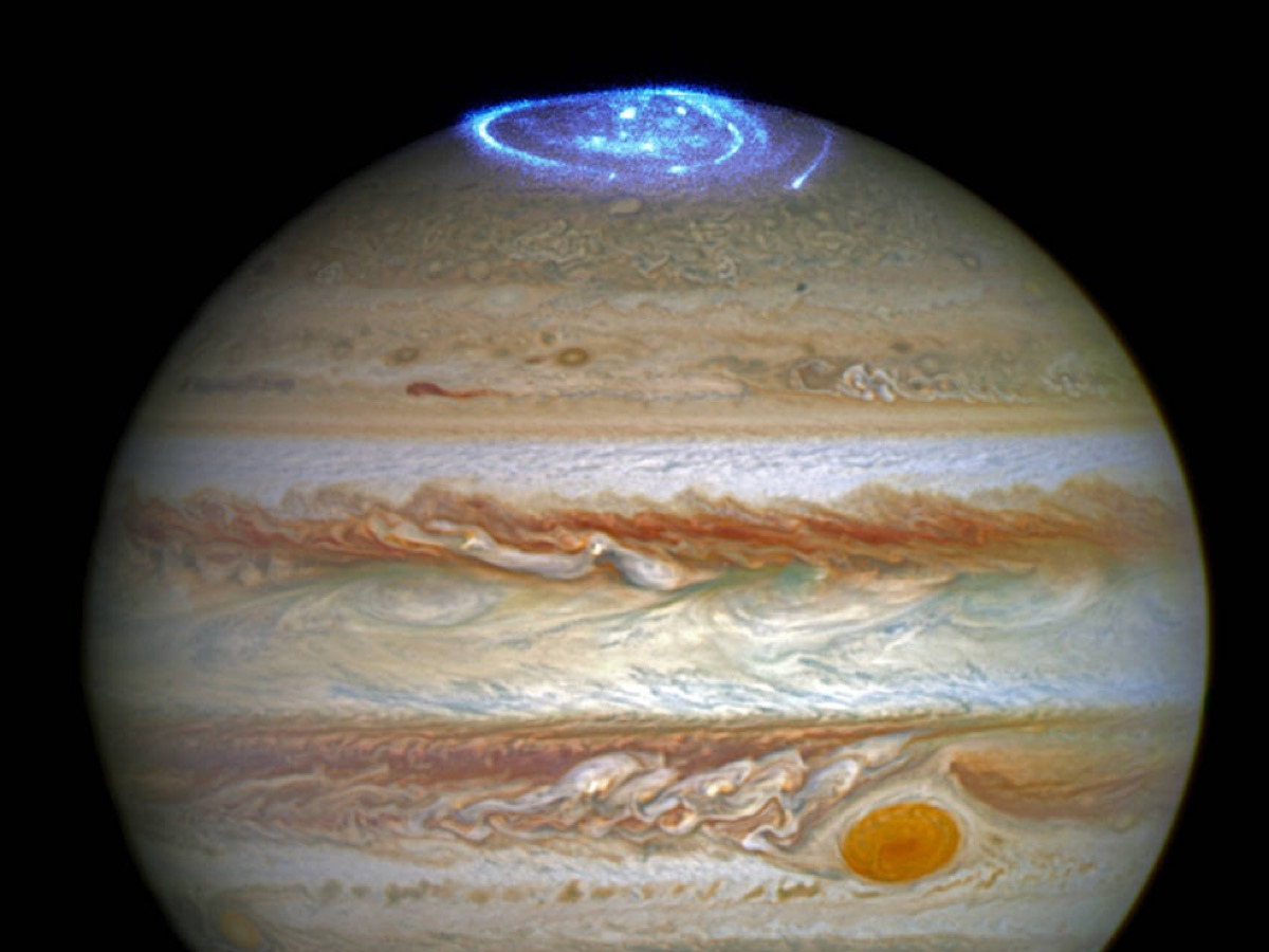 A picture of Jupiter with a blue, swirling aurora at its nother pole.