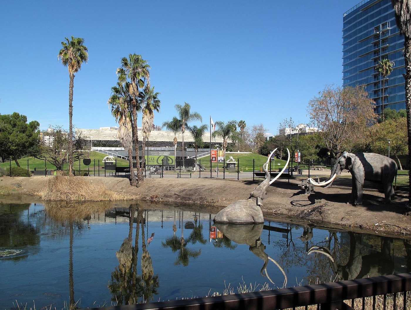 Statues of ancient megafauna, one stuck in a tar pit recreation