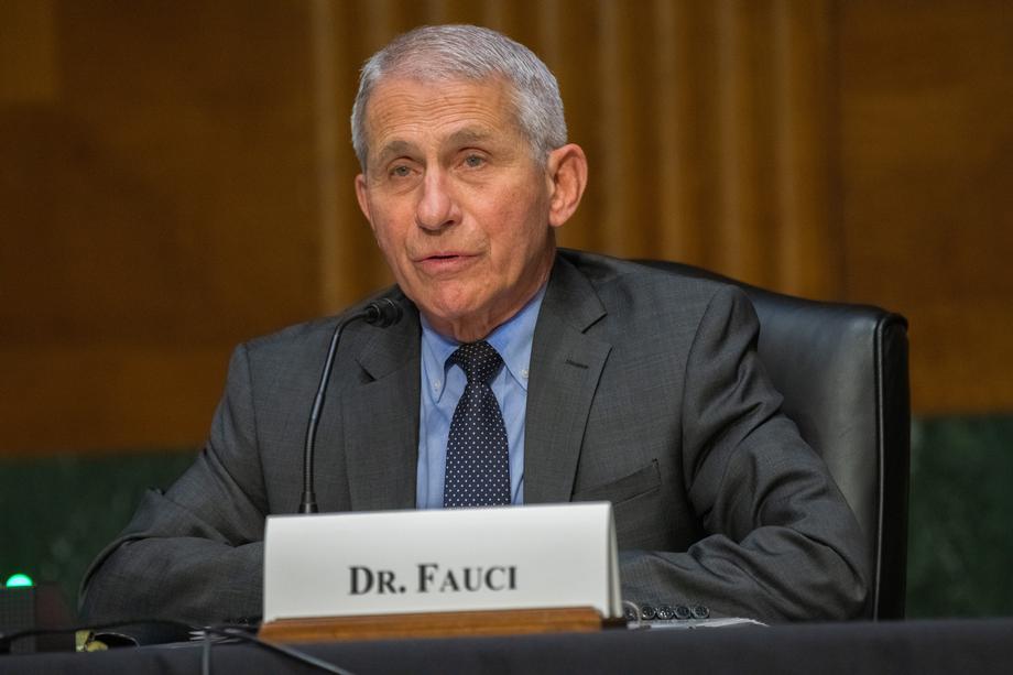 anthony fauci sits in a hearing. a placard says "dr. fauci" in front of him