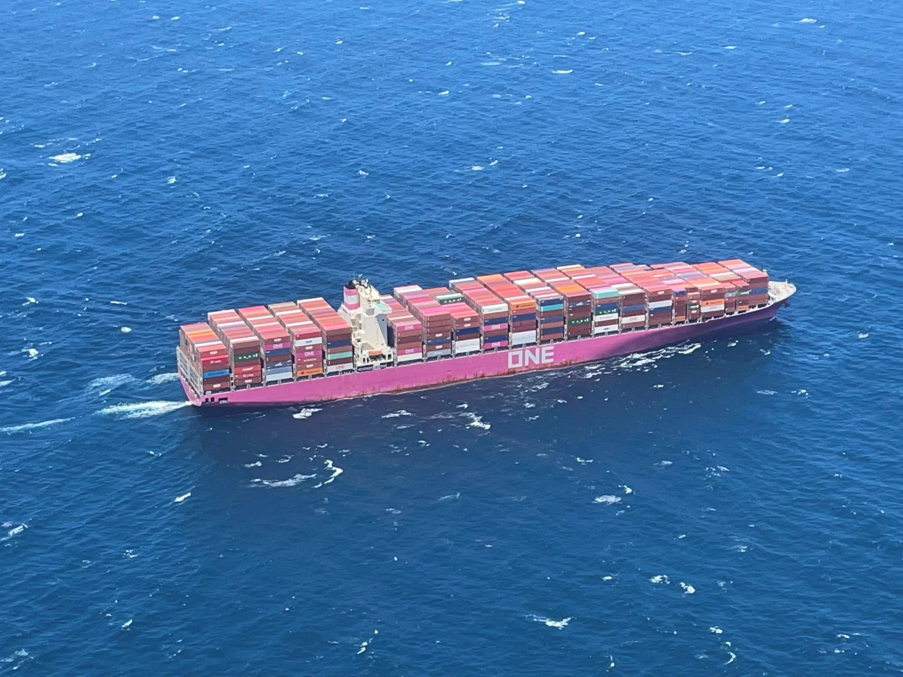 an ariel view of a large container ship making its way through the ocean