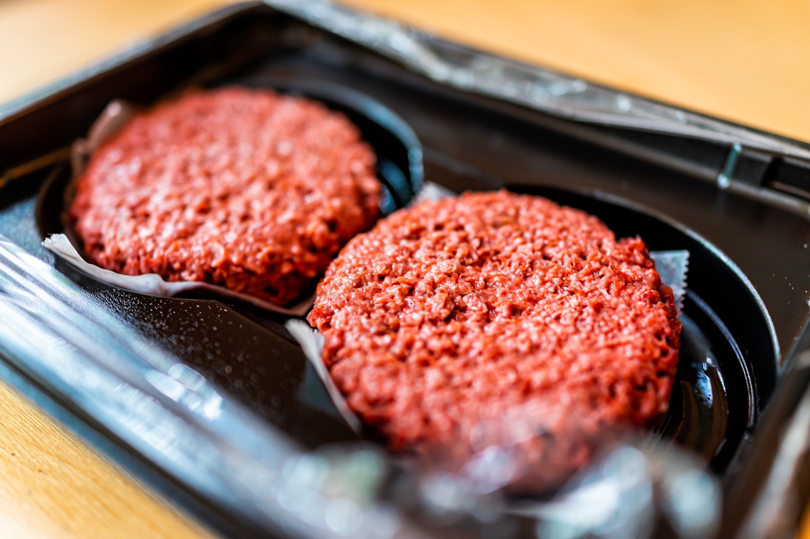 two raw plant-based burger patties, that are slightly more red than a beef-based patty would be