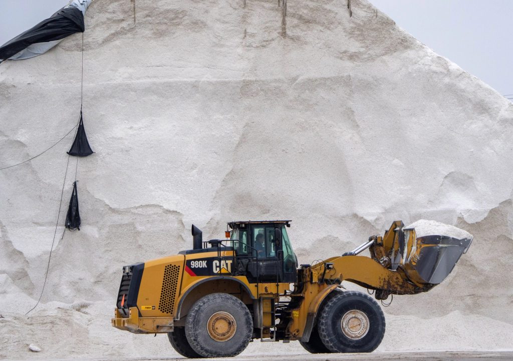 A truck carries salt mined from an enormous salt deposit behind it.