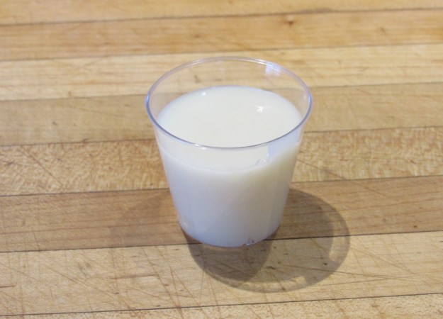 A small glass cup holding a milky white liquid.