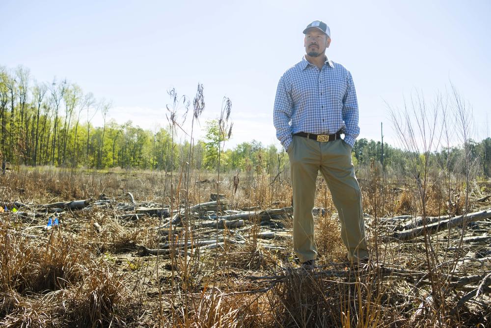 A man standing on tree-planting land.