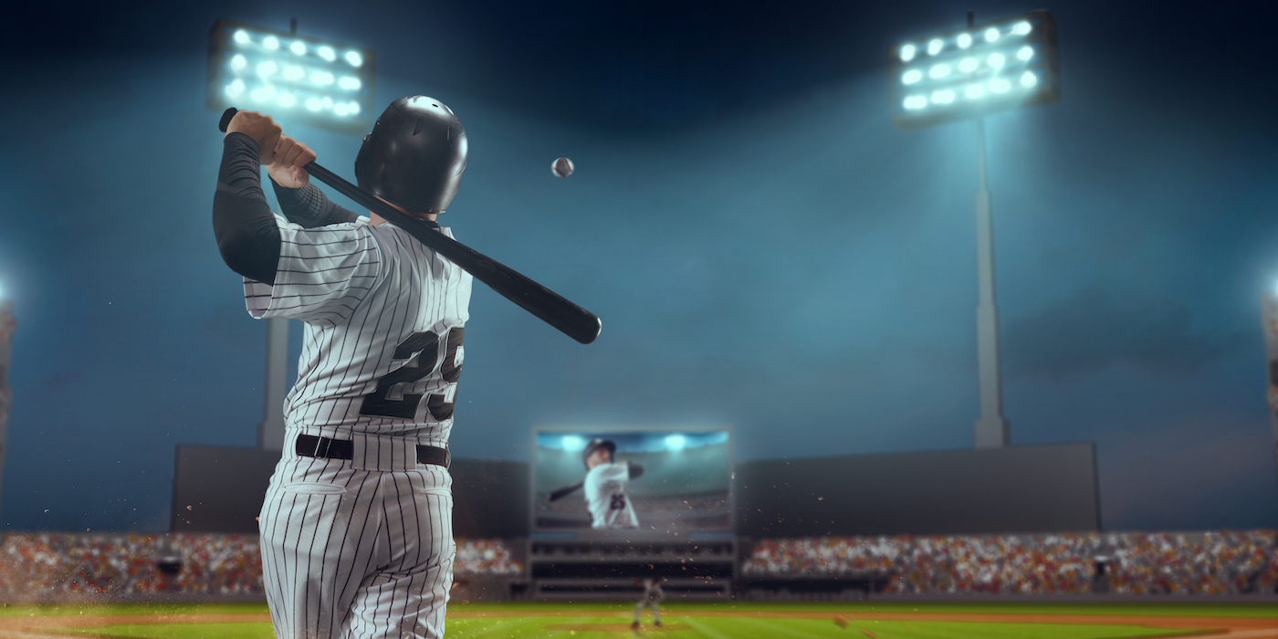 Baseball player bats the ball on professional baseball stadium