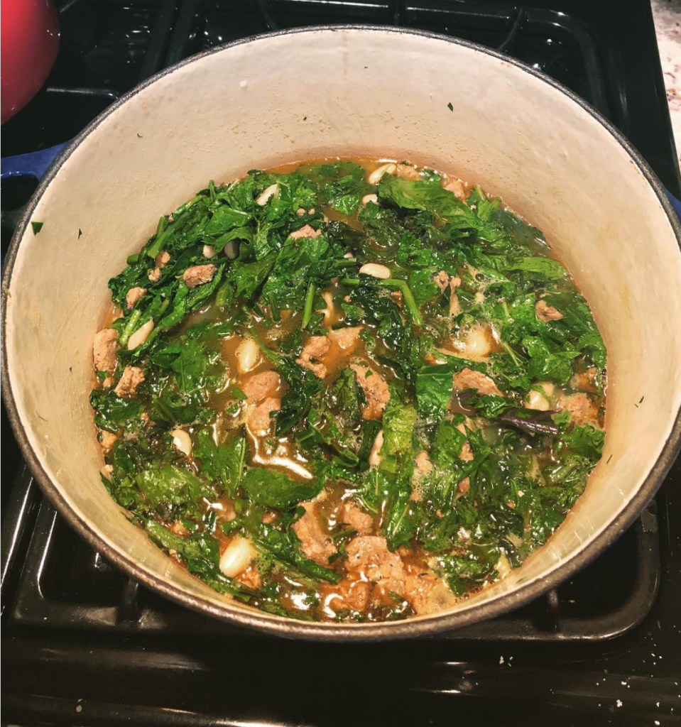 A pot of beans and blanched greens on the stove.