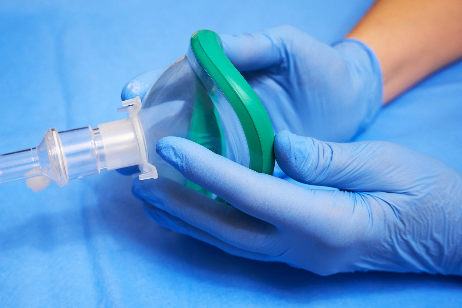 Hands of a medic in gloves holds an anesthesia mask