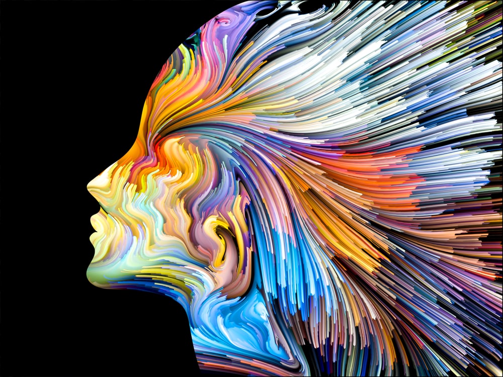 an artistic representation of a profile of a woman - her silhouette is made of streaks of color swirling outward from her mind