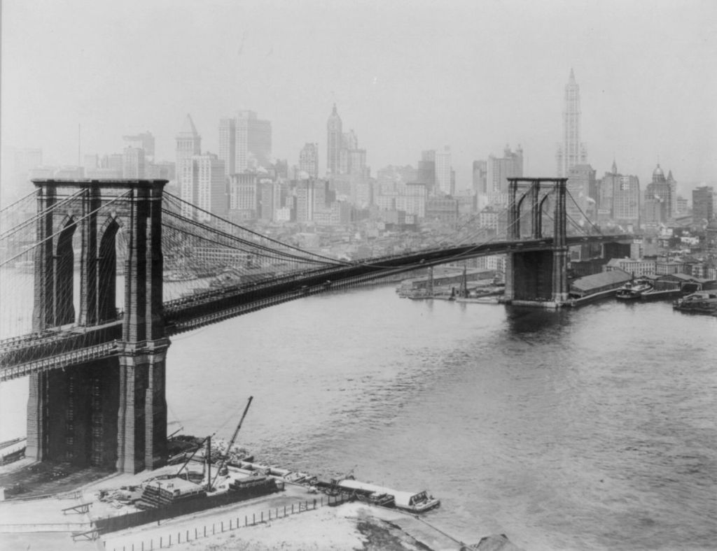 a black and white historical image of a suspension bridge, the brooklyn bridge in new york