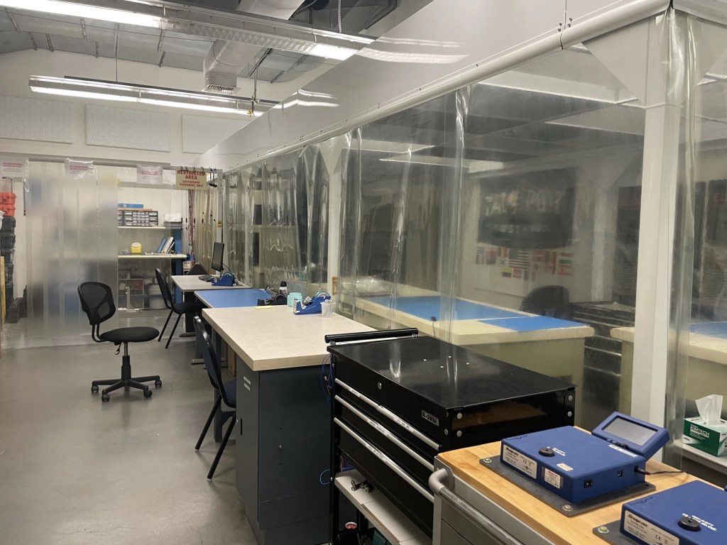 A lab setting with empty desks and chairs.