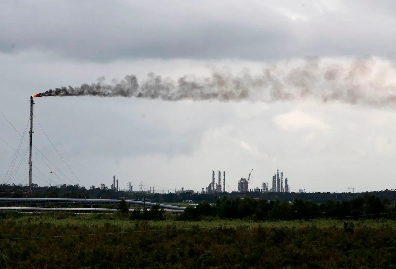A single smoke stack emitting polluting smoke over a landscape.