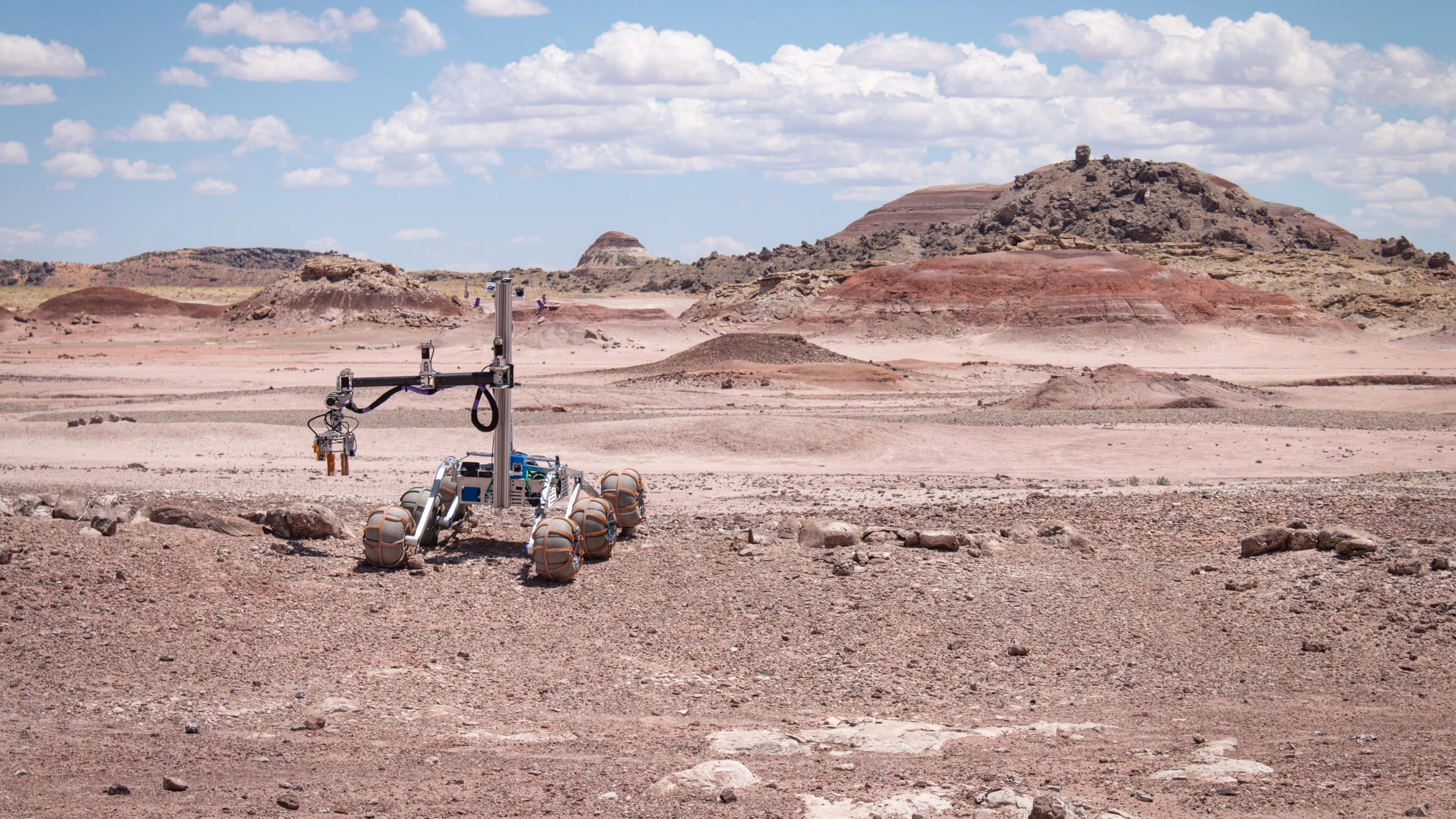 A four wheeled rover drives across a Mars-like desert, that's actually just the desert in Utah.