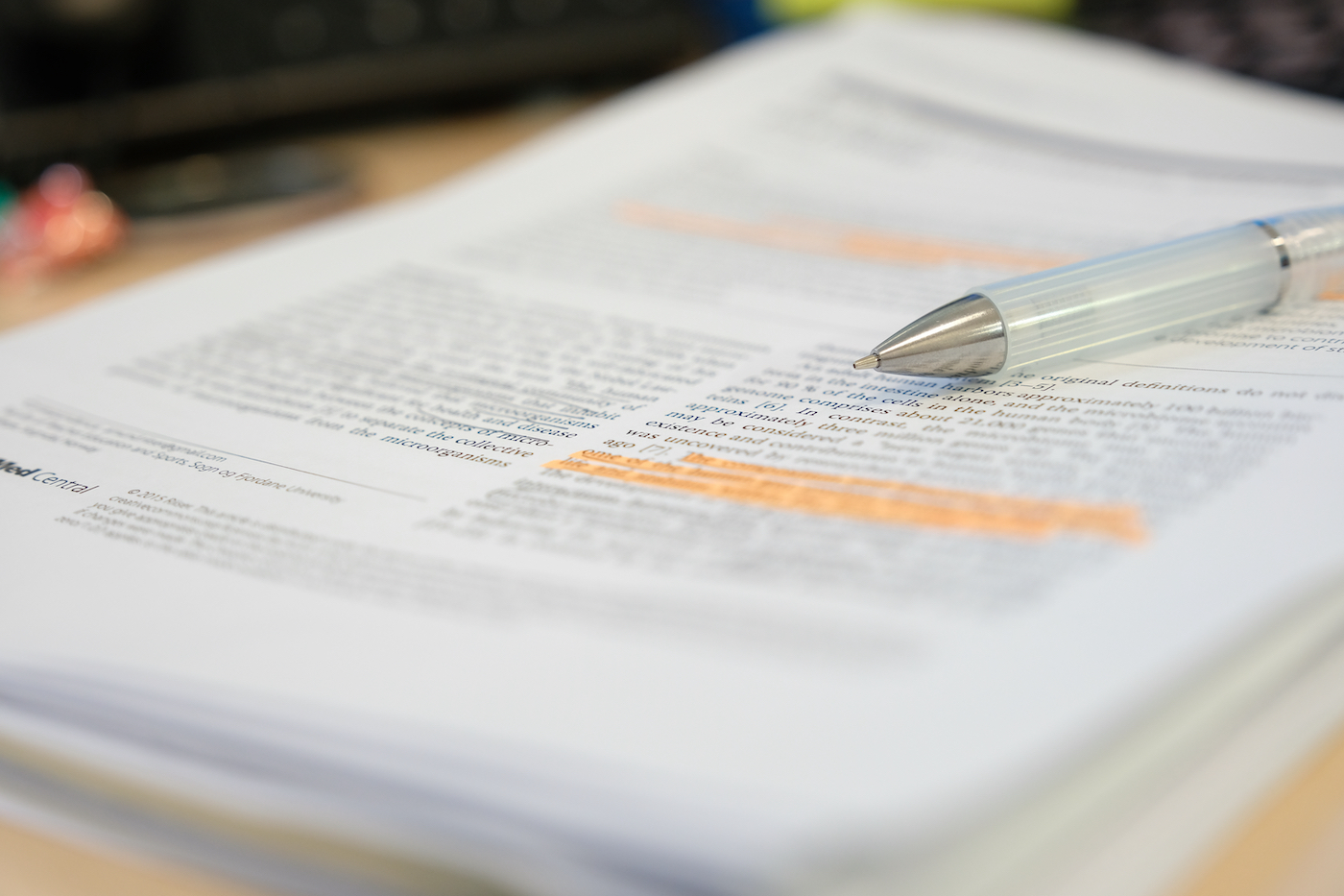 pen sits on top of a scientific study for a scientific journal