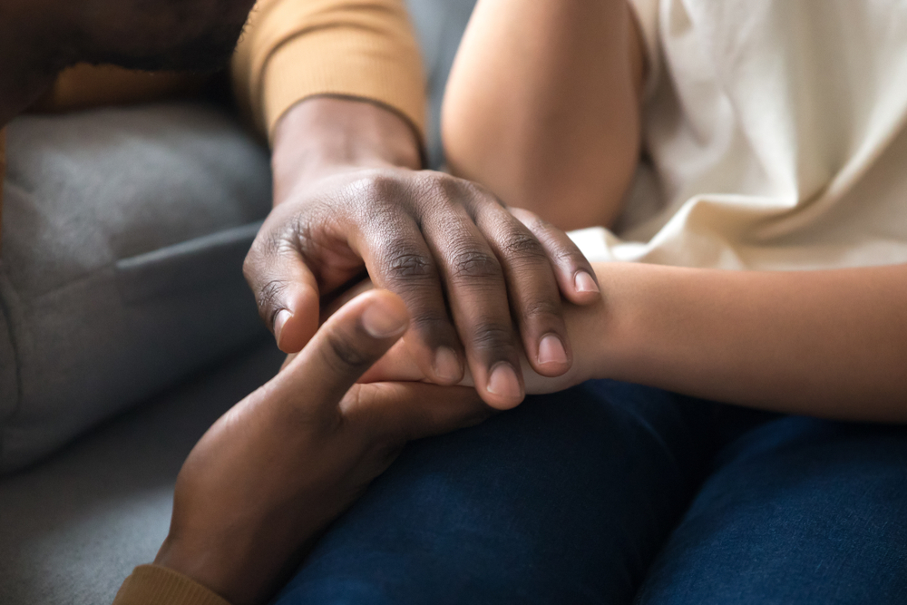 a close up of a black person's hands holding a child's hands