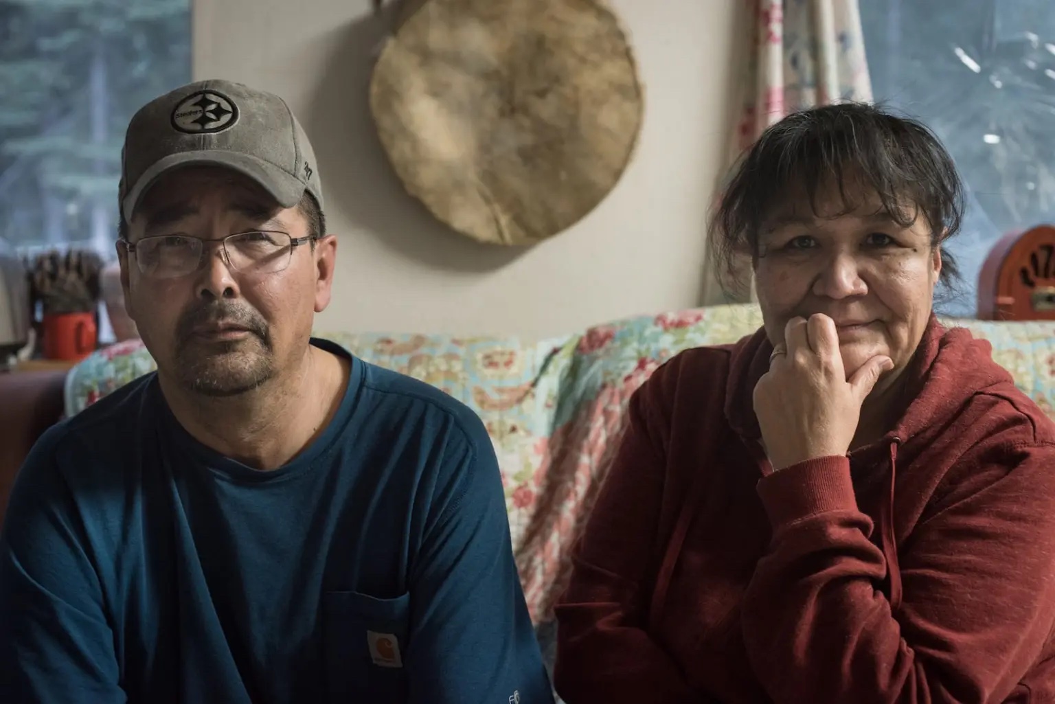 Two Native American people, one man and one woman, look at the camera. 