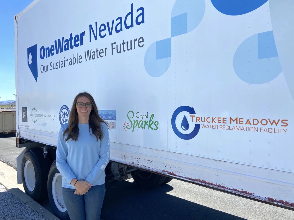 A woman standing in front of a truck that says "OneWater Nevada"