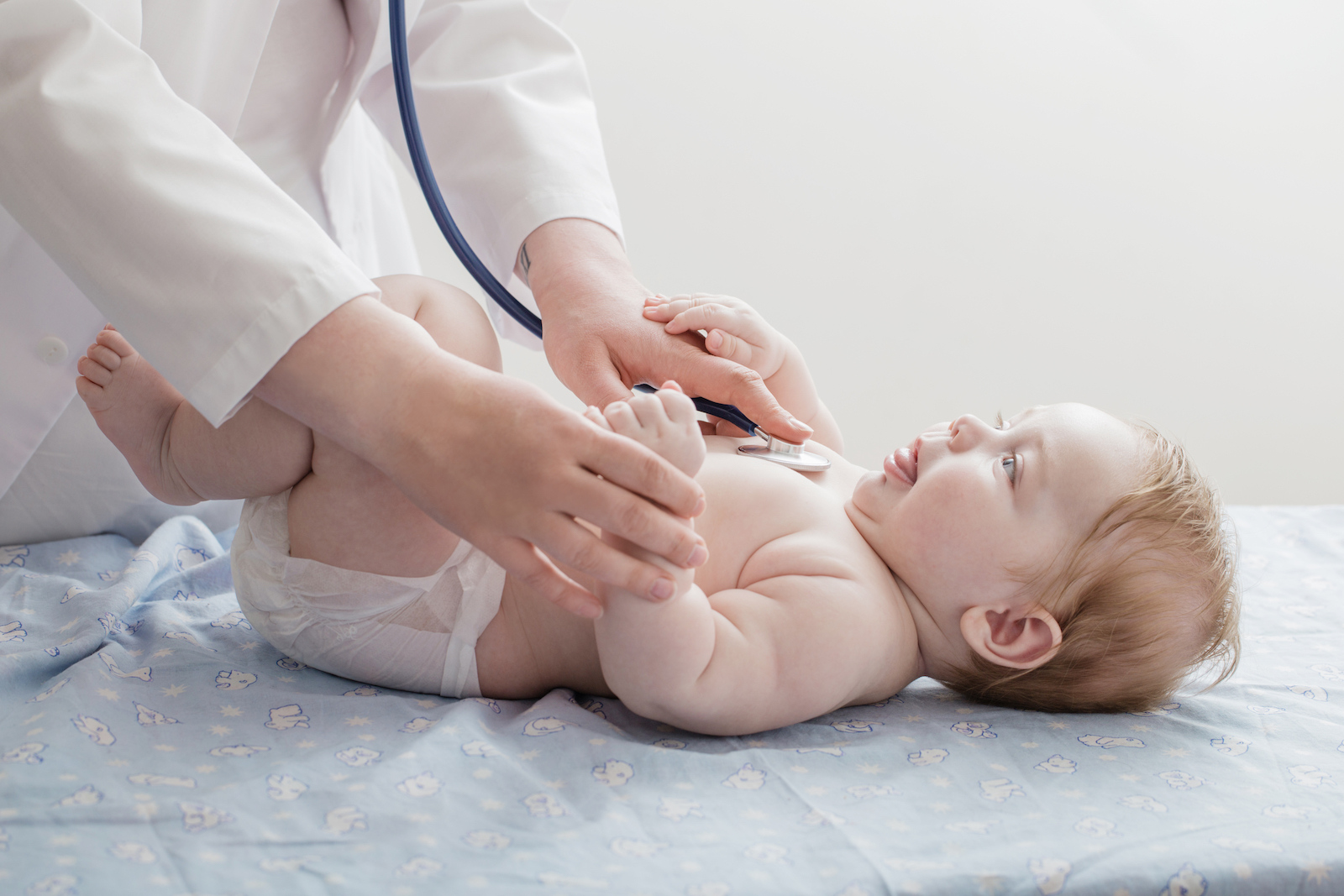 doctor listens to small child with stethoscope