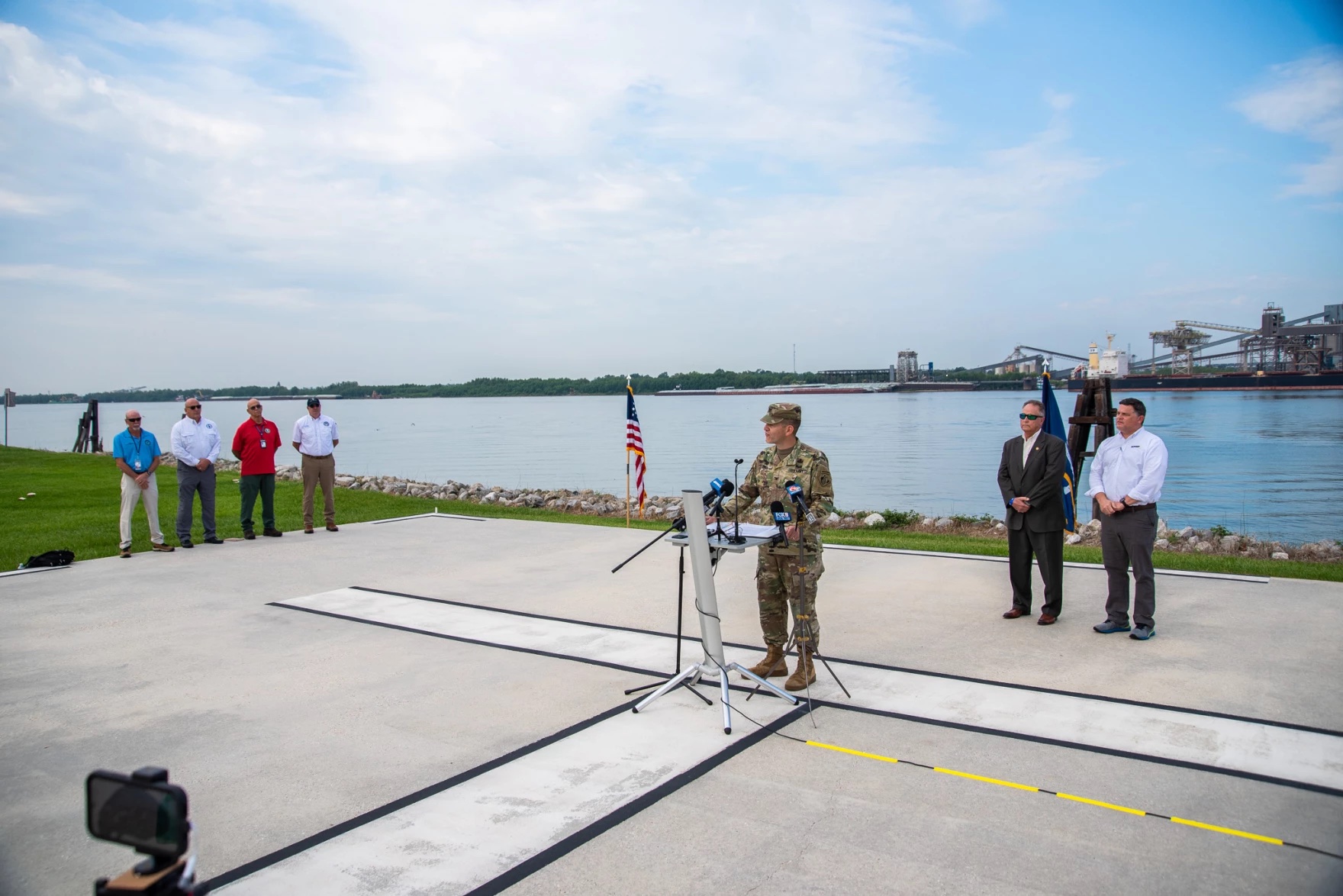 A man in an army uniform speaks at an outdoor press conference.