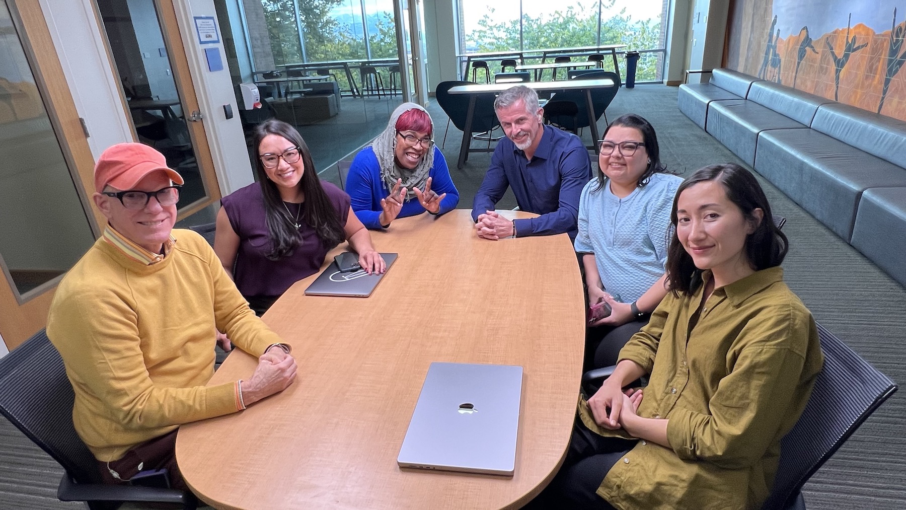 Six people, including Michelle Lichtman and Tamiko Rafeek, sitting at a roundtable, smiling at the camera.