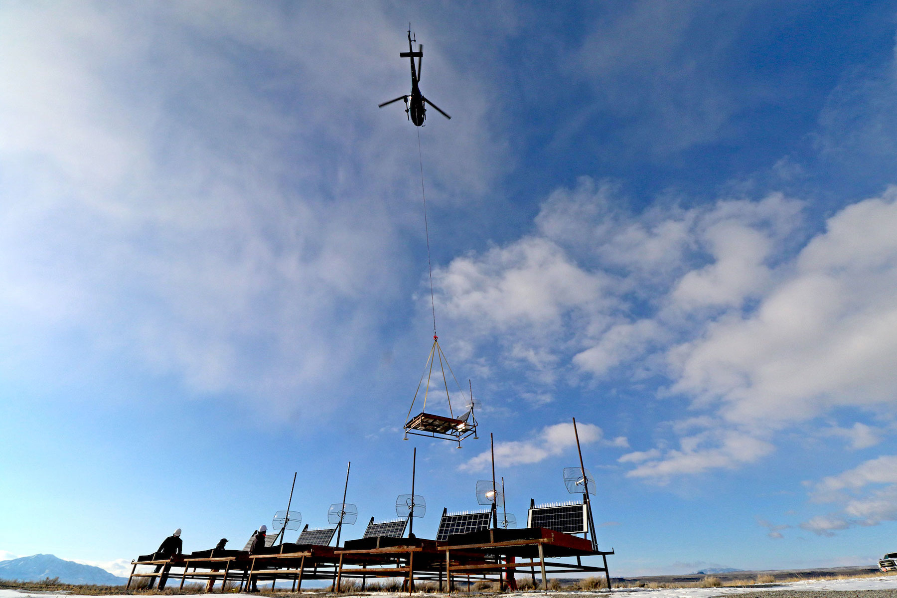 Helicopters lowering cosmic ray detectors.