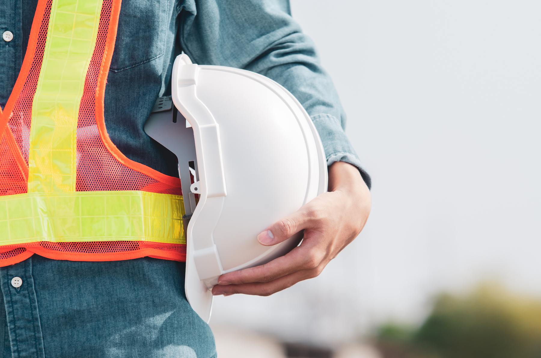 White safety helmet is in the hands of an engineer on site.