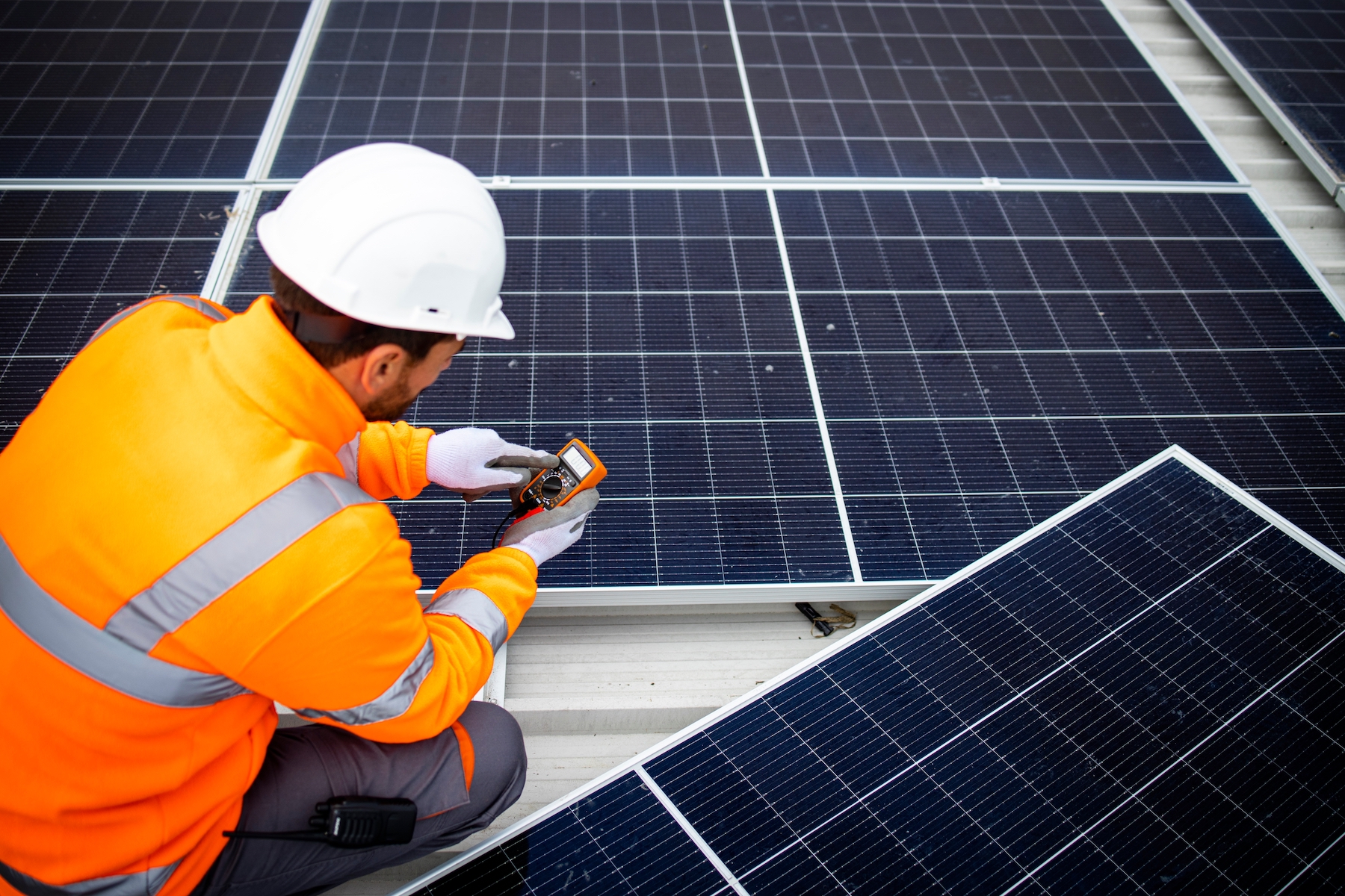 Solar company contractor checking functionality of solar photovoltaic panels.