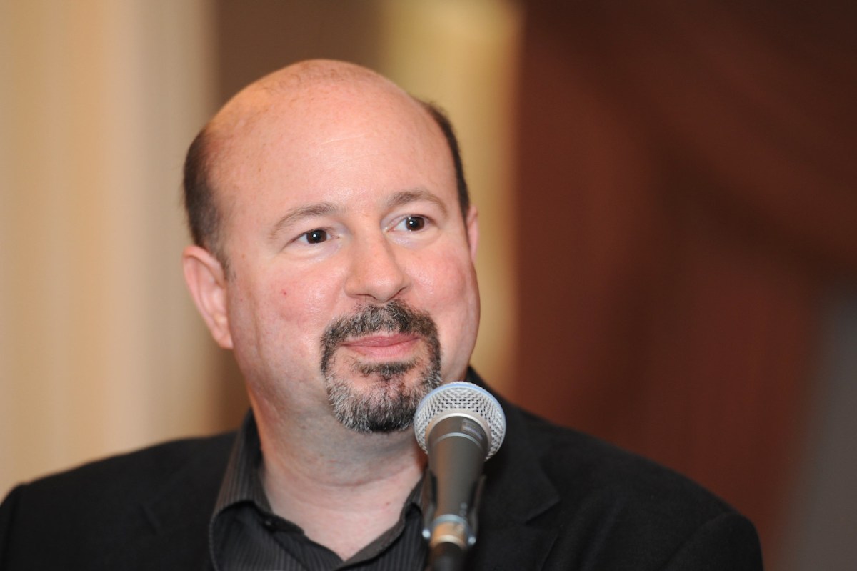 A man looking cheerful behind a microphone