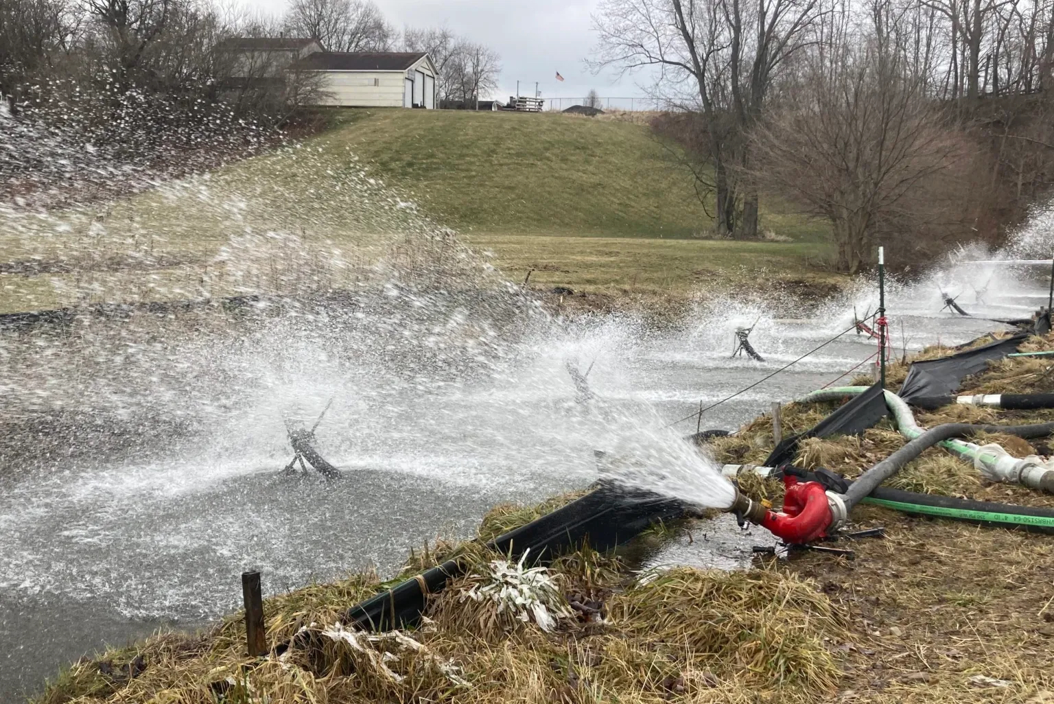 Hoses spraying water over a stream
